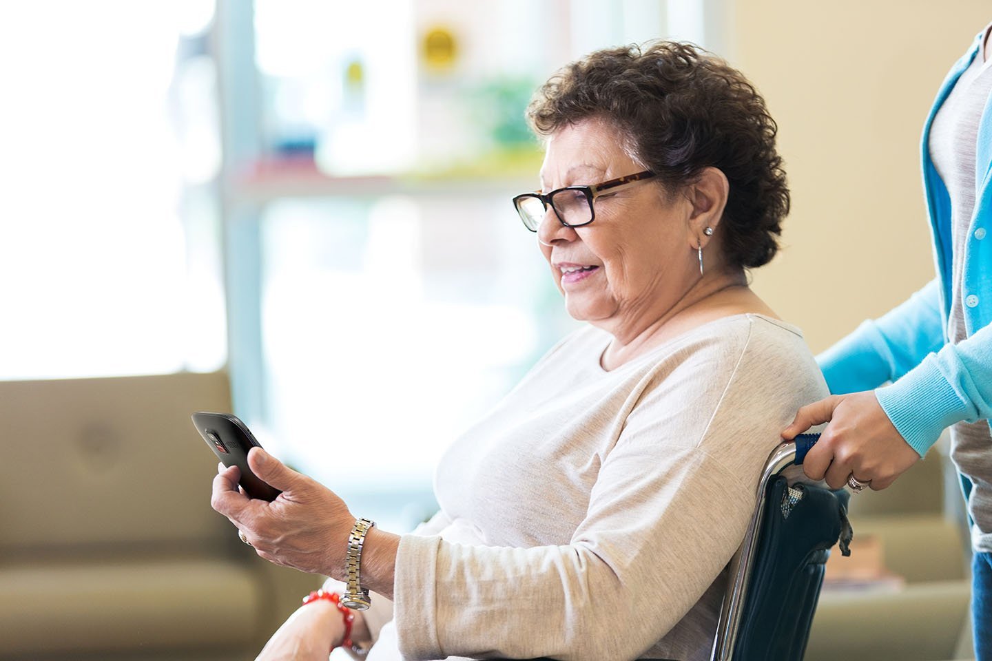 Elderly woman in wheelchair using Snapfōn® ez 4G phone
